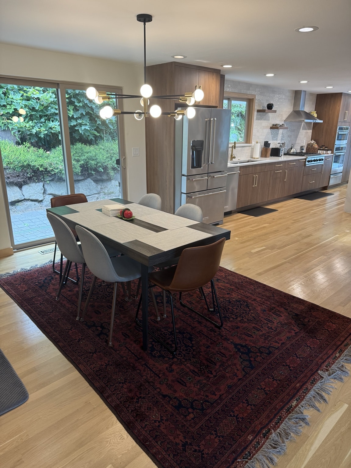 Completed Kirkland kitchen connected to the dining area with new flooring and lighting