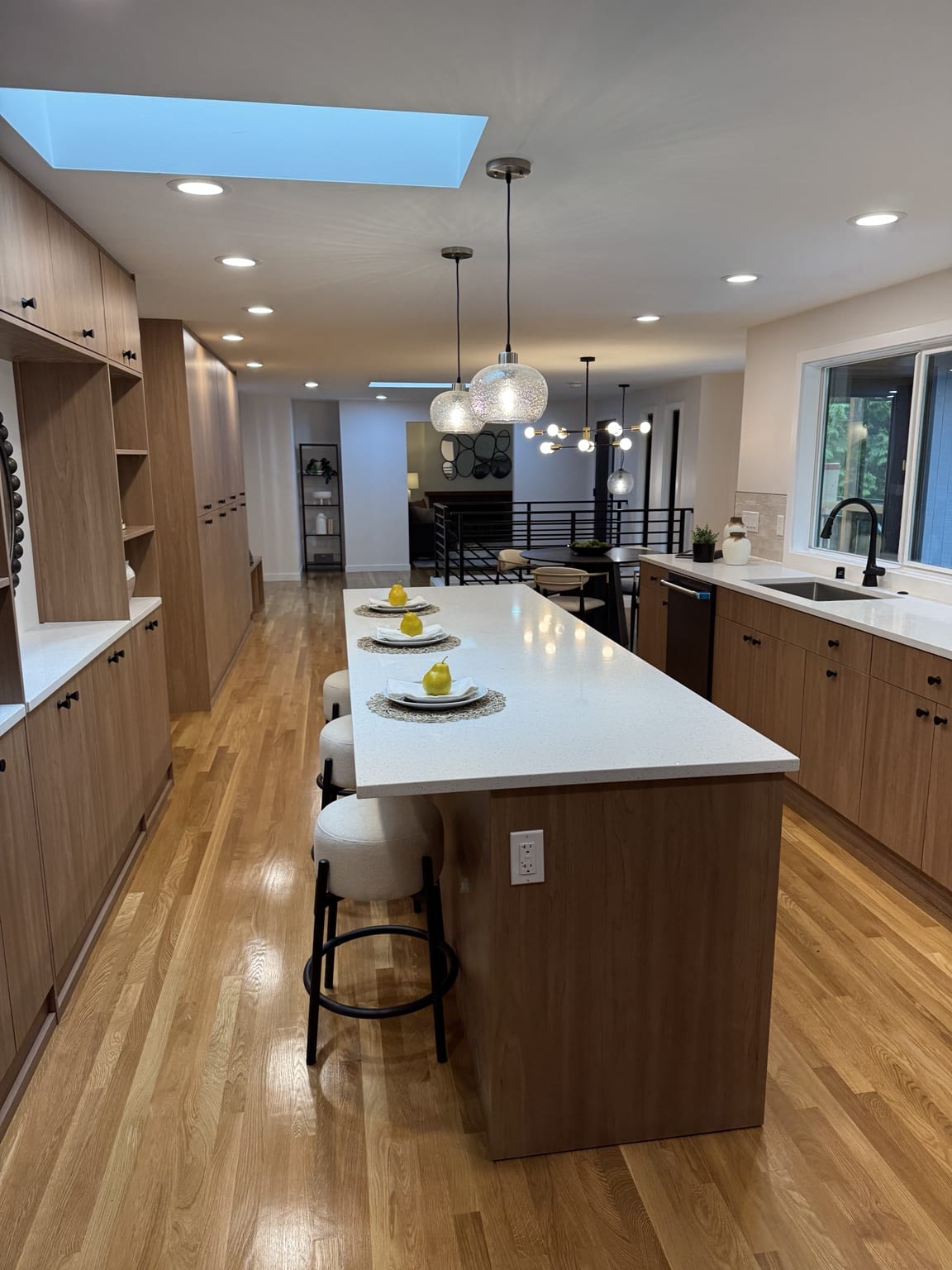 Completed open-concept Mercer Island kitchen remodel with custom wood cabinets, quartz island, new flooring and lighting