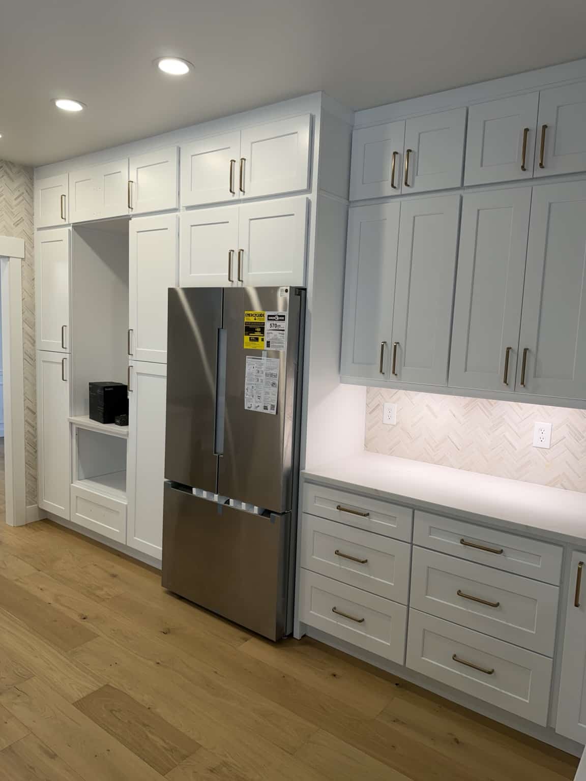 Floor-to-ceiling white kitchen cabinets and quartz counter in North Seattle