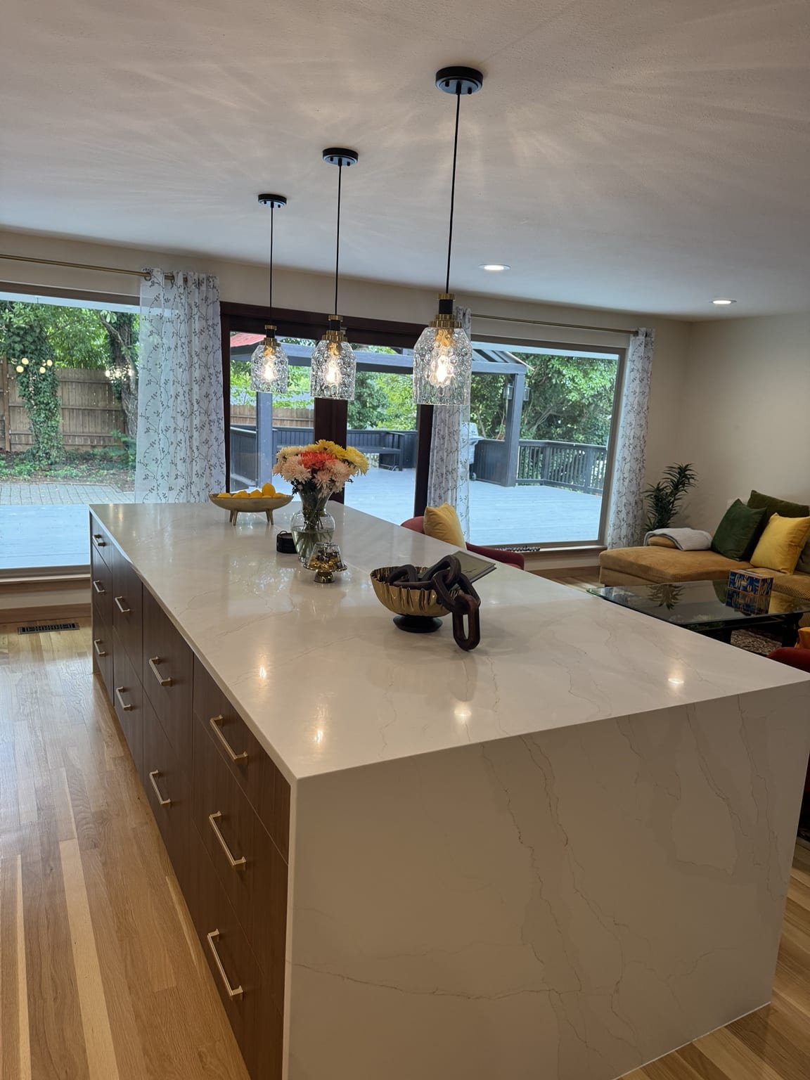 Oversized quartz waterfall island with storage and pendant lighting